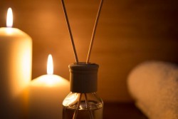 diffuser-stick-close-up-with-candles-and-towel-in-the-background